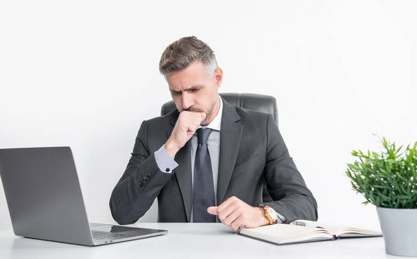 mature businessman sitting in business office having sore throat. - Foto, imagen