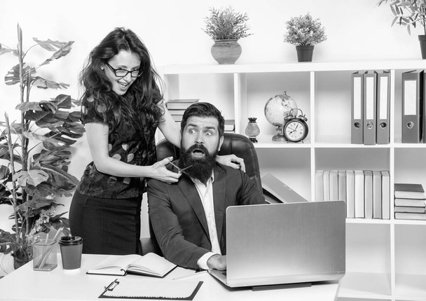 Tricky girl scare bearded man cutting beard with scissors at workplace in office, barber. - Foto, afbeelding
