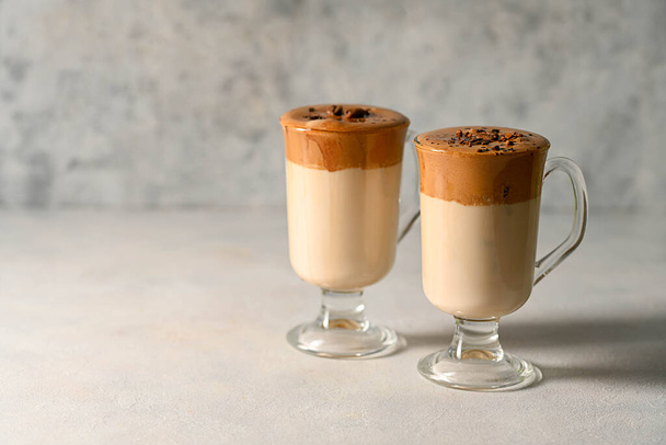 Dalgona coffee. Iced whipped coffee and milk. Refreshing coffee drink in glass cups, copy space - 写真・画像