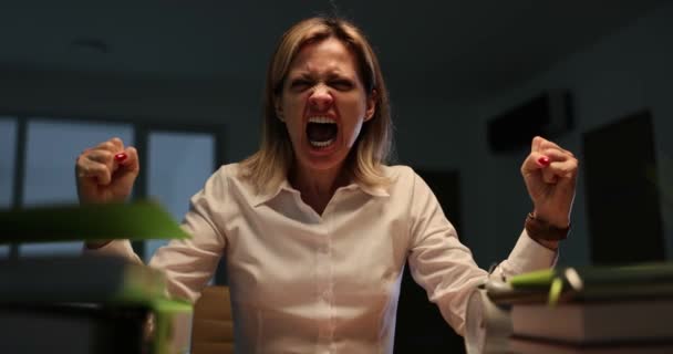 Boze zakenvrouw schreeuwend op kantoor bureau laat op de avond tijdens onweer 4k film. Emotionele burn-out op het werk - Video