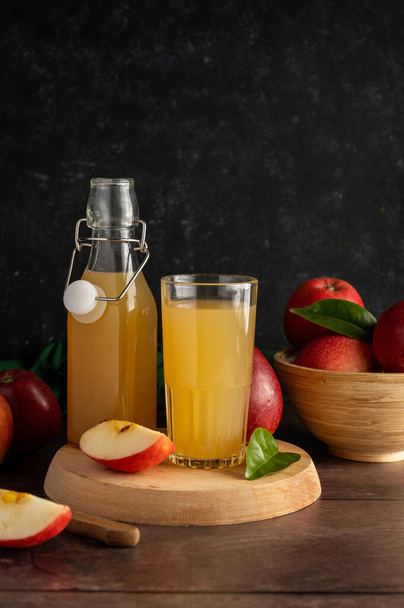 Apple juice drink with fresh red apples, wooden background. Copy space. - Photo, image