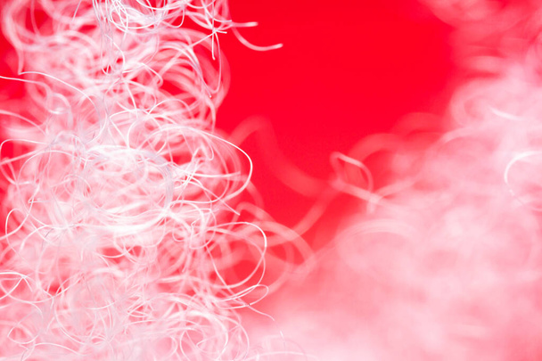 Extreme macro of polyester stable fiber on red background. Selective focus, shallow depth of field. Abstract dreamy background - Φωτογραφία, εικόνα