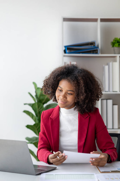 Молодая американка - начинающая предпринимательница, сидит в офисе, управляя и управляя бизнесом от молодого поколения. Концепция управления стартапом. - Фото, изображение