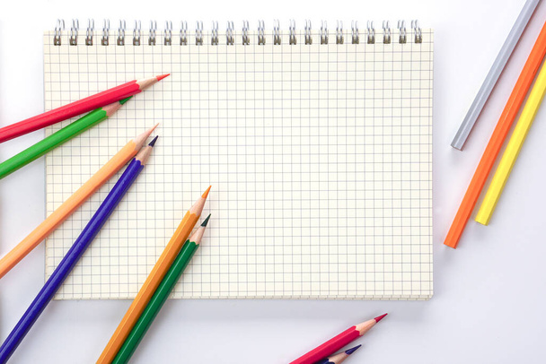 Värilliset kynät tai pastelli sijoitetaan kuvakirjan. Oppimisen, opiskelun ja esittelyn käsite. - Valokuva, kuva