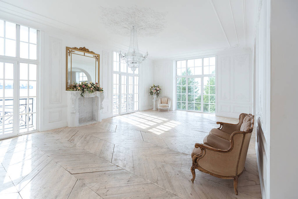 chic white huge spacious hall with a minimum of expensive antique furniture. Baroque interior design with ornament on the walls and parquet on the floor. - Fotografie, Obrázek