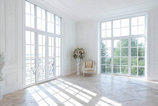 chic white huge spacious hall with a minimum of expensive antique furniture. Baroque interior design with ornament on the walls and parquet on the floor. - Foto, Imagem