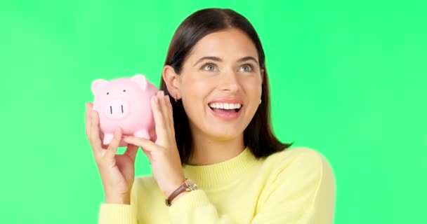 Happy woman, face and money with piggy bank on green screen for investment, budget or finance against a studio background. Portrait of excited female holding savings for coin, profit or investing. - Footage, Video