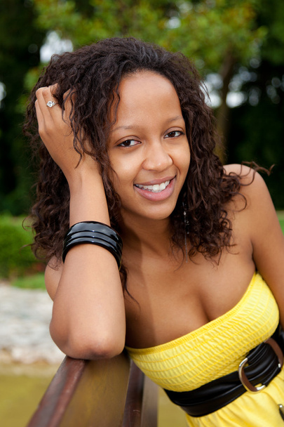 Beautiful african american woman sitting on a bench - Foto, imagen