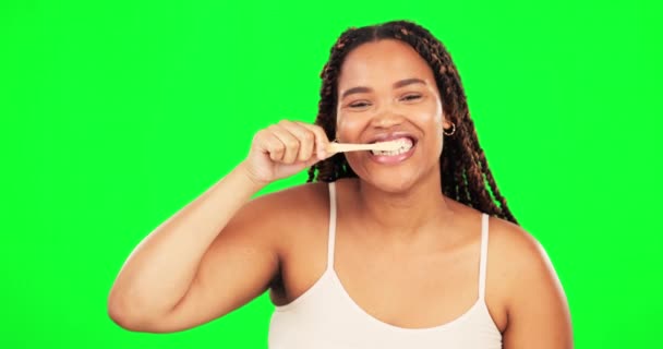 Tela verde, rosto e mulher feliz escovando dentes em estúdio para o bem-estar dental saudável. Retrato de modelo feminino, escova de dentes e boca de limpeza para respiração fresca, manutenção oral e cuidado do sorriso. - Filmagem, Vídeo