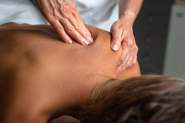 Massage procedure - neck and whole body massage by a female masseuse. doing massaging using oil. neck and whole body massage, relaxing massage, strong hands of a masseur, massage to increase work efficiency - Foto, Imagem