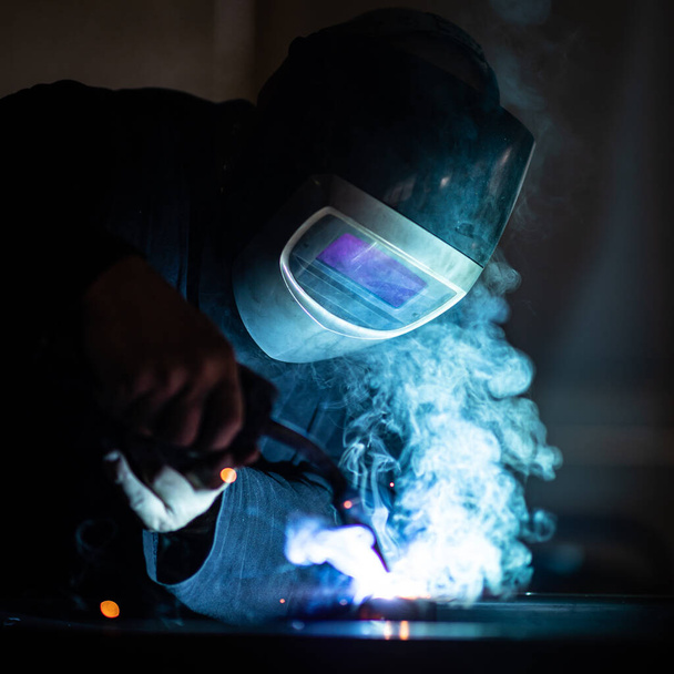 Man working on iron with grinder. Man at work. Sparkles and fire from grinder cutting. Grinder. Worker. - Photo, Image