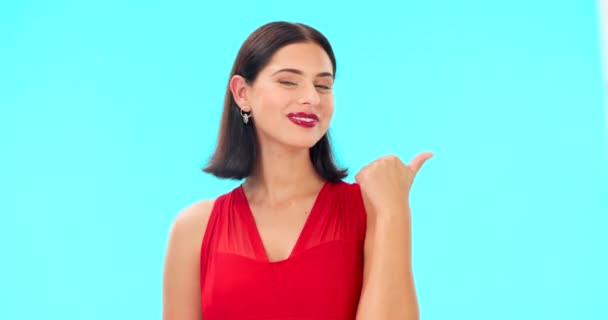 Woman face, pointing and studio with beauty, happiness and smile showing mockup for advertisement. Portrait, isolated and blue background with a happy young female point to show mock up announcement. - Footage, Video
