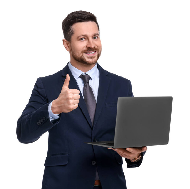 Handsome bearded businessman in suit with laptop showing thumb up on white background - Фото, изображение