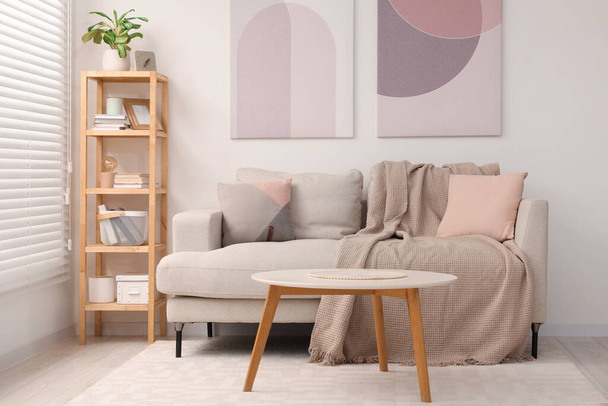 Stylish living room interior with sofa, coffee table and wooden shelf - Φωτογραφία, εικόνα