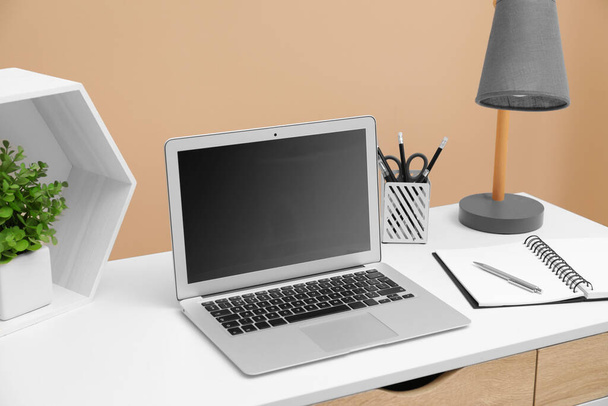 Cozy workplace with laptop and stationery on desk. Home office - Fotoğraf, Görsel