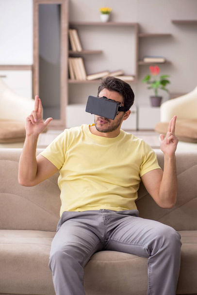 Giovane studente maschio godendo occhiali virtuali a casa - Foto, immagini