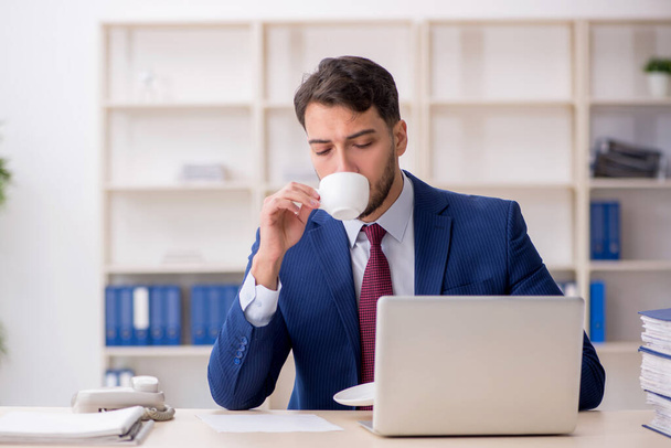 Jovem funcionário bebendo café durante o intervalo - Foto, Imagem