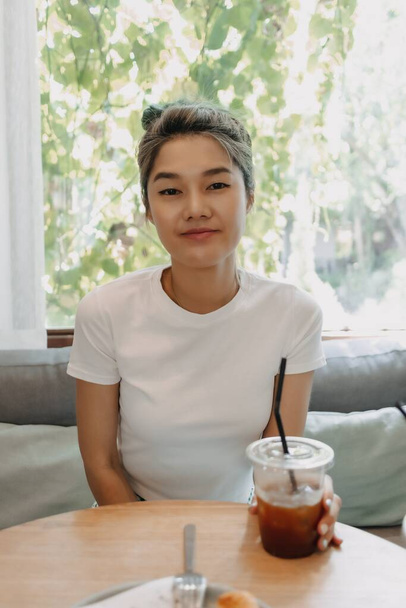 Beautiful and cute asian woman drinking iced coffee in the cafe. - Foto, Imagem