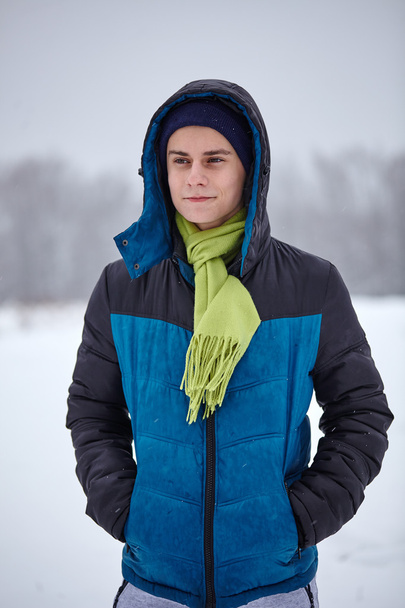 Teenage boy standing on a snowy field - Фото, зображення