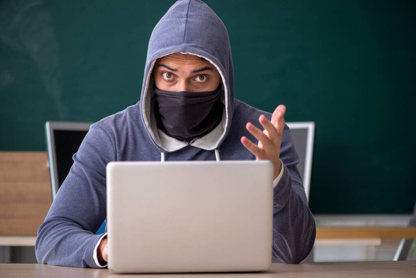 Jonge hacker zit in de klas - Foto, afbeelding