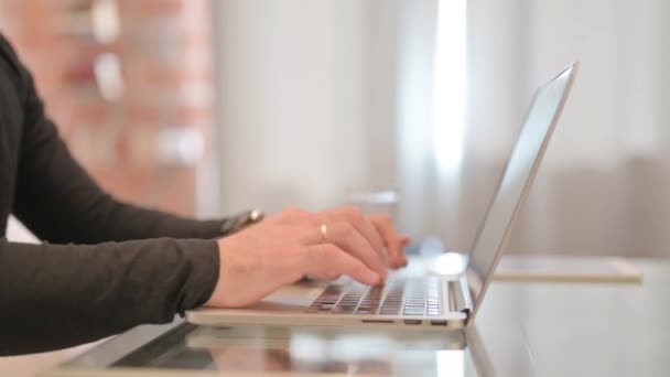 Vista lateral del hombre trabajando en el ordenador portátil - Imágenes, Vídeo