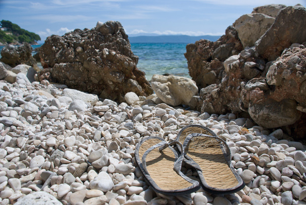 Parmak arası terlik Hırvat taş sahilde  - Fotoğraf, Görsel