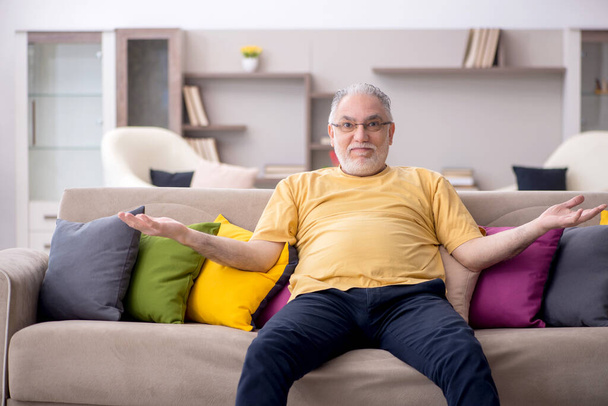 У віці чоловік з багатьма подушками вдома
 - Фото, зображення