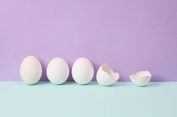 Kreative Gestaltung mit Eiern auf pastellfarbenem Hintergrund. Konzeptpop. Minimales Stillleben. Ernährungskonzept - Foto, Bild