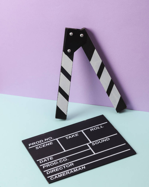 Creative retro 80s layout with movie clapperboard on pastel background. Conceptual pop. Minimal still life - Photo, Image