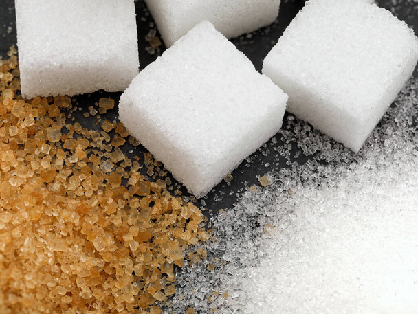 closeup of three different types of sugar, white refined granulated sugar, brown cane sugar and sugar cubes. - Photo, Image