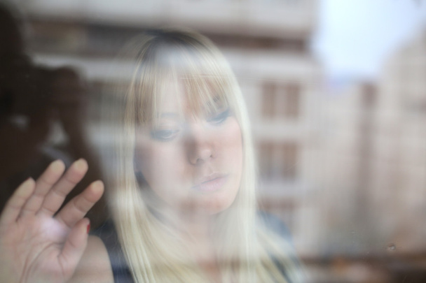 Portrait of beautiful blonde through the glass - Foto, afbeelding