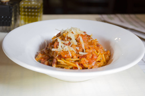 Nudeln al pomodoro ist eine italienische Mahlzeit, die typischerweise mit Nudeln, Olivenöl, frischen Tomaten, Basilikum und anderen frischen Zutaten zubereitet wird. Es soll ein schnelles und leichtes Gericht sein, nicht ein Gericht mit dicker Soße. Pomodoro bedeutet auf Italienisch "Tomate". - Foto, Bild