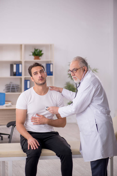 Young patient visiting old male doctor - Foto, Imagem