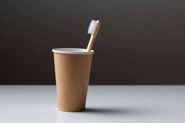 Toothbrush in a cardboard ecological cardboard cup, hygiene health care. - Photo, Image