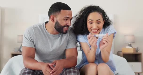 Happy couple, bedroom and positive pregnancy test results, joy and excited hugging for future family. Life, love and man with pregnant woman hug and celebrate good news sitting on bed with excitement. - Footage, Video