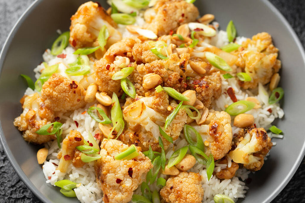Coliflor de Kung Pao con arroz, maní y especias. Comida vegana saludable - Foto, Imagen