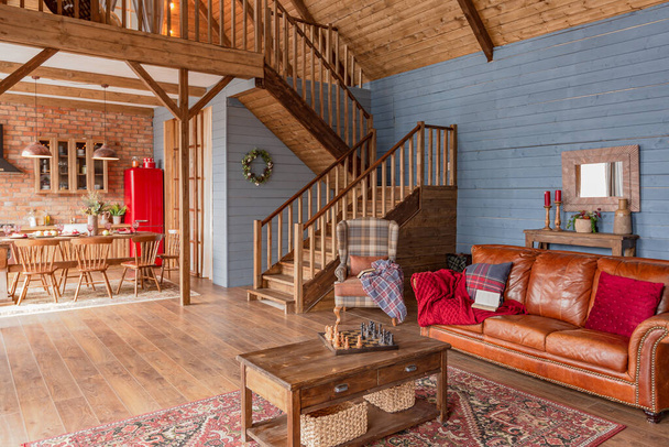 cozy all wooden interior of a country house in a wooden design. spacious living room with kitchen area with large windows. bedroom on the second floor. - Fotoğraf, Görsel