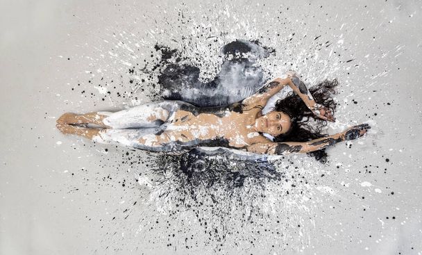 sexy naga kobieta w czarno-białym kolorze malowane, leżące dekoracyjne na białym, czarnym, szarym piętrze Studio. Kreatywna, abstrakcyjna ekspresyjna sztuka ciała i malarstwo, przestrzeń kopiująca - Zdjęcie, obraz