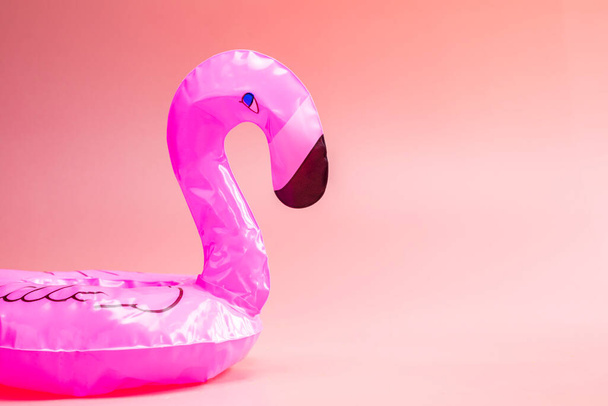 Flamingo inflable sobre un fondo rosa, fondo de verano, fiesta de flotador de piscina, espacio de concepto de verano de moda para texto - Foto, Imagen