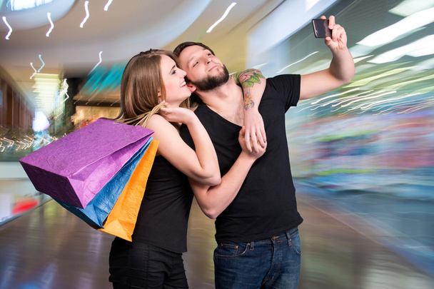Happy couple with shopping bags taking selfie - Photo, Image