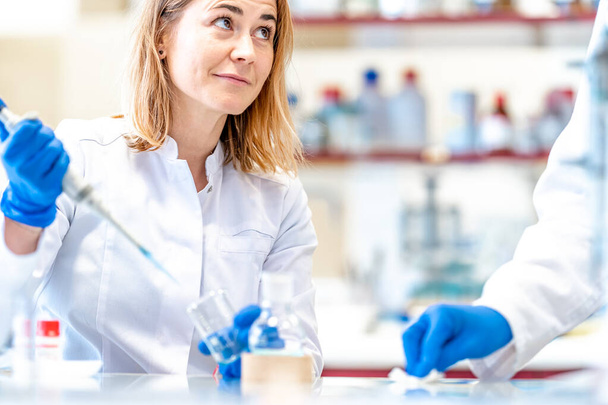 若い女性科学者は研究室で医療産業のための新しい薬をテストしています.  - 写真・画像