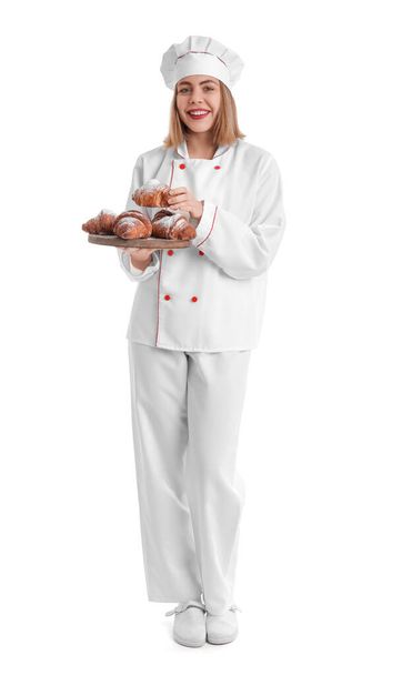 Female baker with board of tasty croissants on white background - Foto, afbeelding
