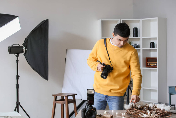 Fiatal férfi fotós professzionális kamera dolgozik stúdióban - Fotó, kép