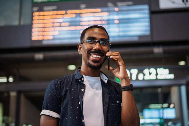 Homem africano falando ao telefone enquanto espera em uma estação de trem - Foto, Imagem
