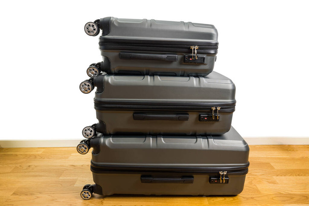 Vue rapprochée de trois valises sur roues de différentes tailles sur parquet dans la chambre. Suède. - Photo, image