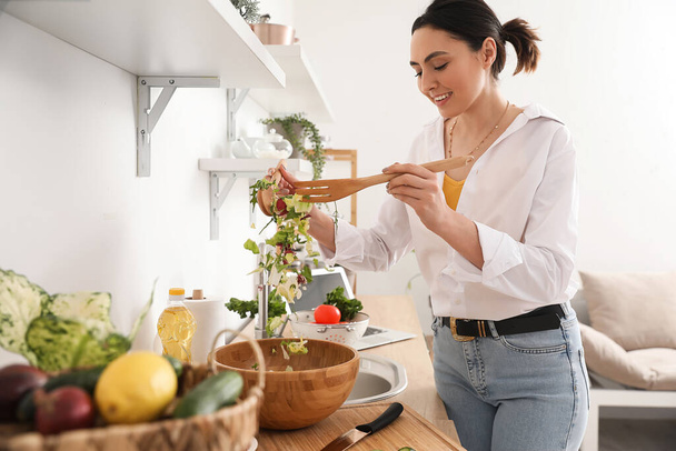 Nuori nainen tekee vihannessalaattia keittiössä - Valokuva, kuva