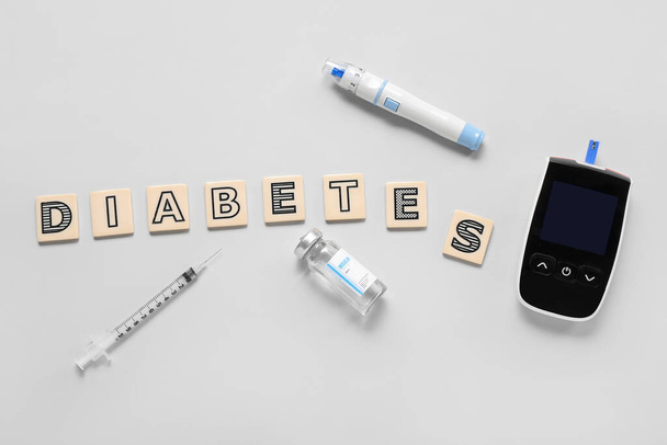 Word DIABETES with insulin, glucometer and lancet pen on grey background - Fotografie, Obrázek