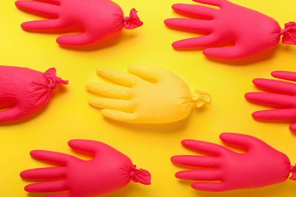 Φουσκωμένα ιατρικά γάντια σε κίτρινο φόντο - Φωτογραφία, εικόνα