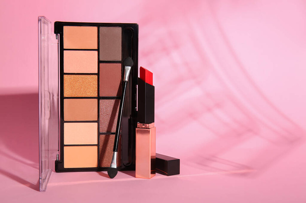 Eyeshadows with lipstick and brush on pink background - Photo, Image