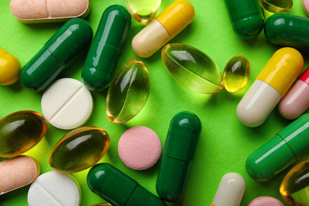 Different pills on green background, closeup - Foto, afbeelding
